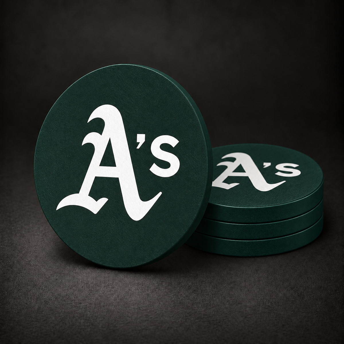 Oakland Athletics Drink Coasters with dark green sides, three stacked and one standing on a dark charcoal background