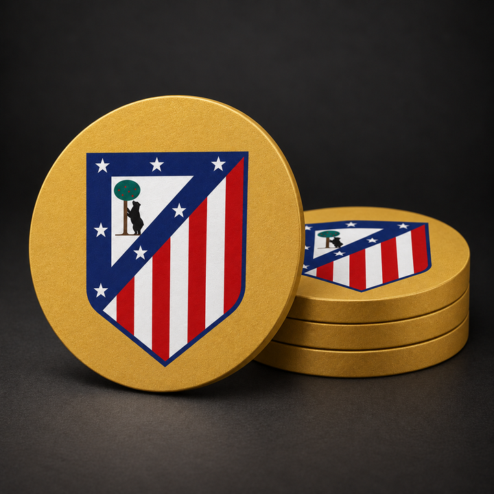 Atlético Madrid Drink Coasters with gold sides, three stacked and one standing on a dark charcoal background