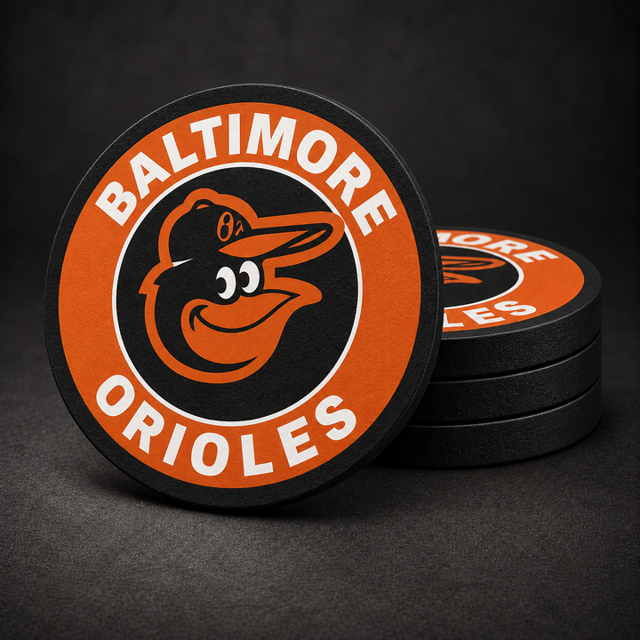 Baltimore Orioles Drink Coasters with black sides, three stacked and one standing on a dark charcoal background