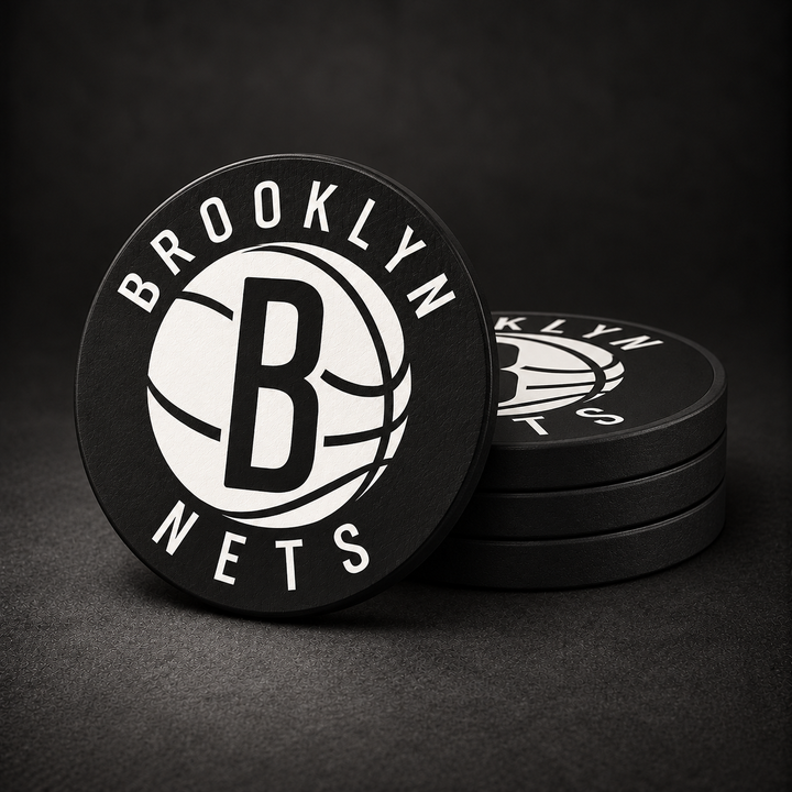 Brooklyn Nets Drink Coasters with black sides, three stacked and one standing on a dark charcoal background