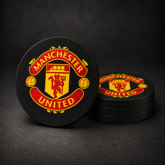 Manchester United Drink Coasters with black sides, three stacked and one standing on a dark charcoal background