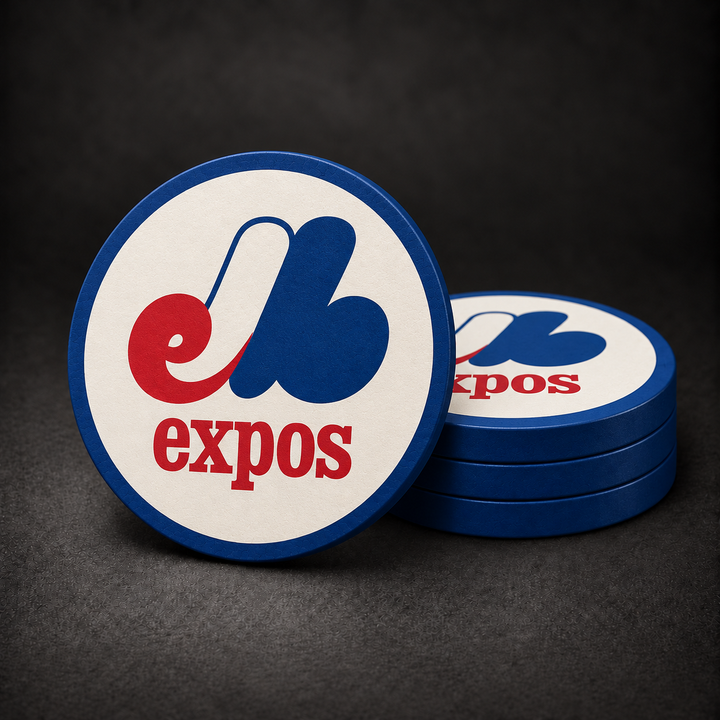 Montreal Expos Drink Coasters with blue sides, three stacked and one standing on a dark charcoal background