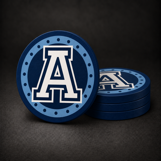 Toronto Argonauts Drink Coasters with navy blue sides, three stacked and one standing on a dark charcoal background