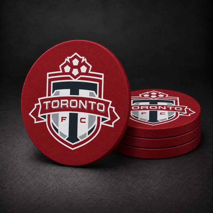 Toronto FC Drink Coasters with burgundy red sides, three stacked and one standing on a dark charcoal background