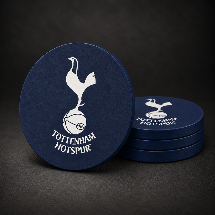 Tottenham Hotspur F.C. Drink Coasters with navy blue sides, three stacked and one standing on a dark charcoal background