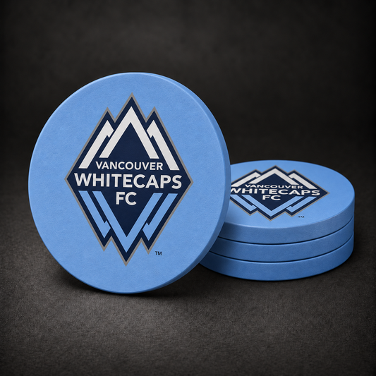 Vancouver Whitecaps FC Drink Coasters with light blue sides, three stacked and one standing on a dark charcoal background